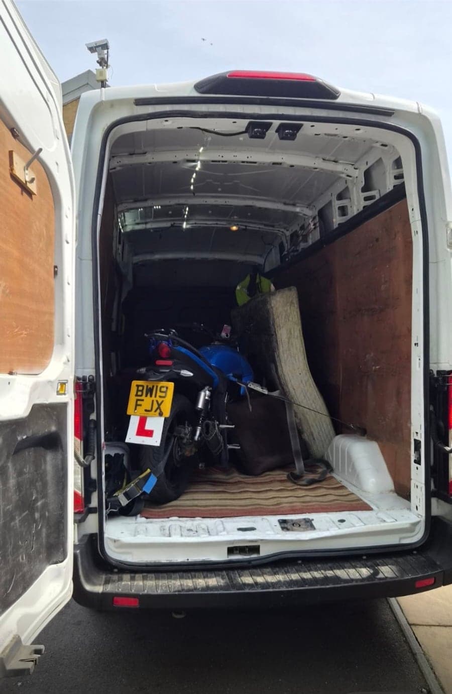 Motorcycle and household items loaded into a Raymond Logistics van